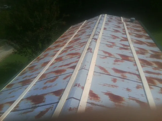 Rusted metal roof panels with new wood purlins before replacement — Storm Damage Roof Repair in University Park by Roofing Brothers